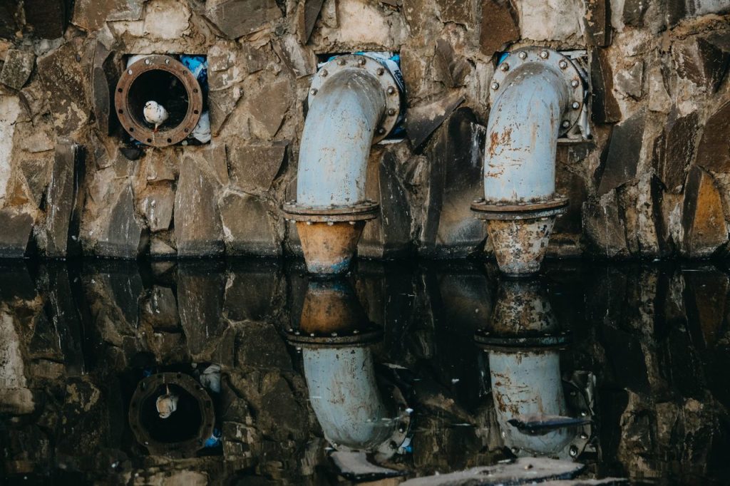 The Art of Drawing Readers In: Your attractive post title goes here A seagull perches on rusty industrial pipes reflecting in the water at Ribeirão Preto, Brazil.